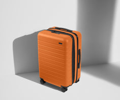 Angled product view of The Bigger Carry-On Flex suitcase in Sorbet Orange