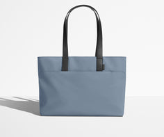 Front view of The Everywhere Tote with its leather handles up