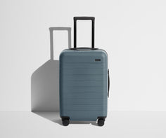 Front product view of The Carry-On suitcase in Coast Blue with raised handle