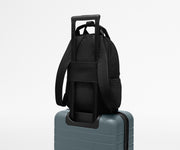 Featherlight Backpack on top of an Away suitcase, attached by the trolley sleeve