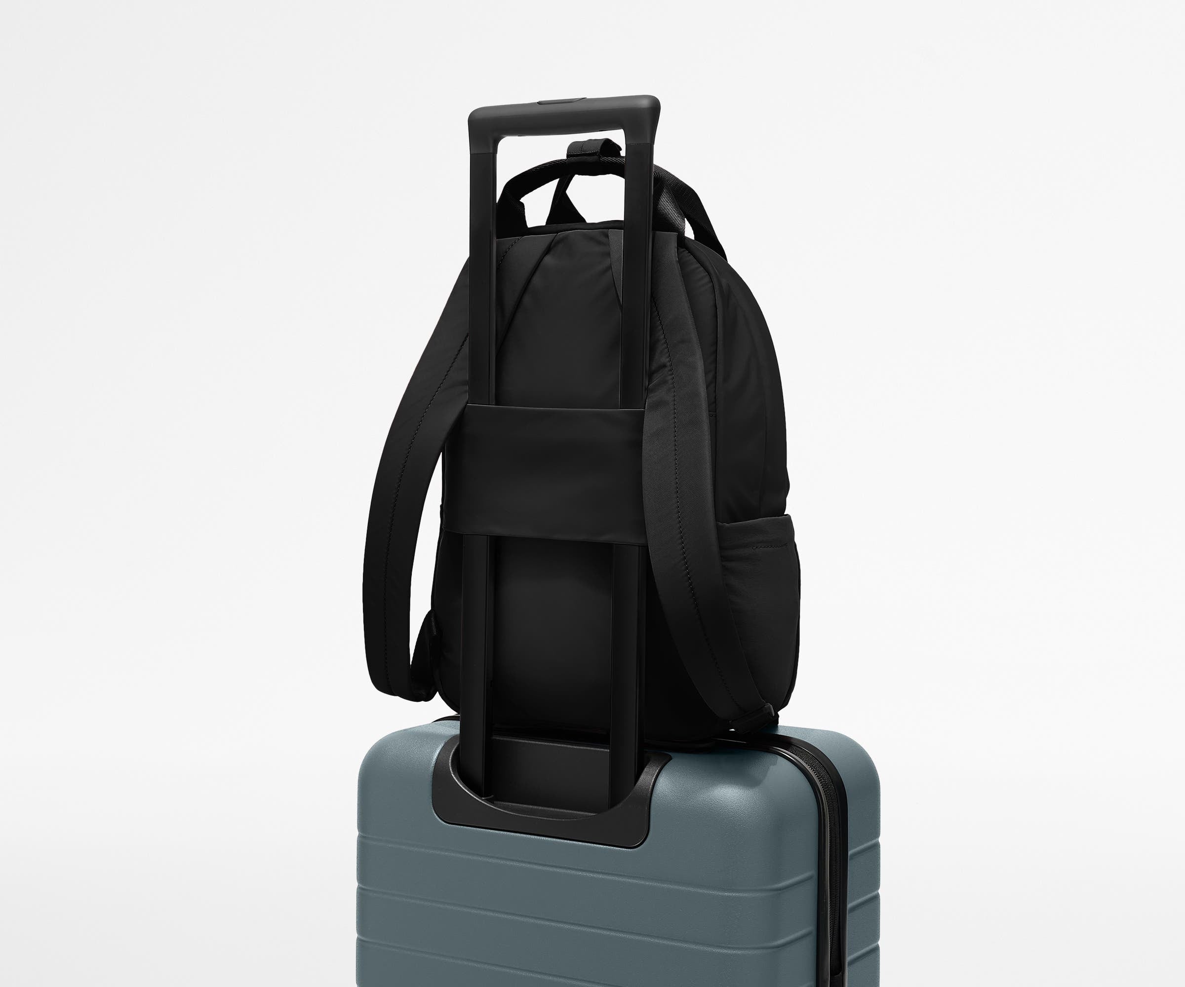 Featherlight Backpack on top of an Away suitcase, attached by the trolley sleeve