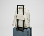 Back view of the Courtside Everywhere Zip Backpack on top of an Away suitcase