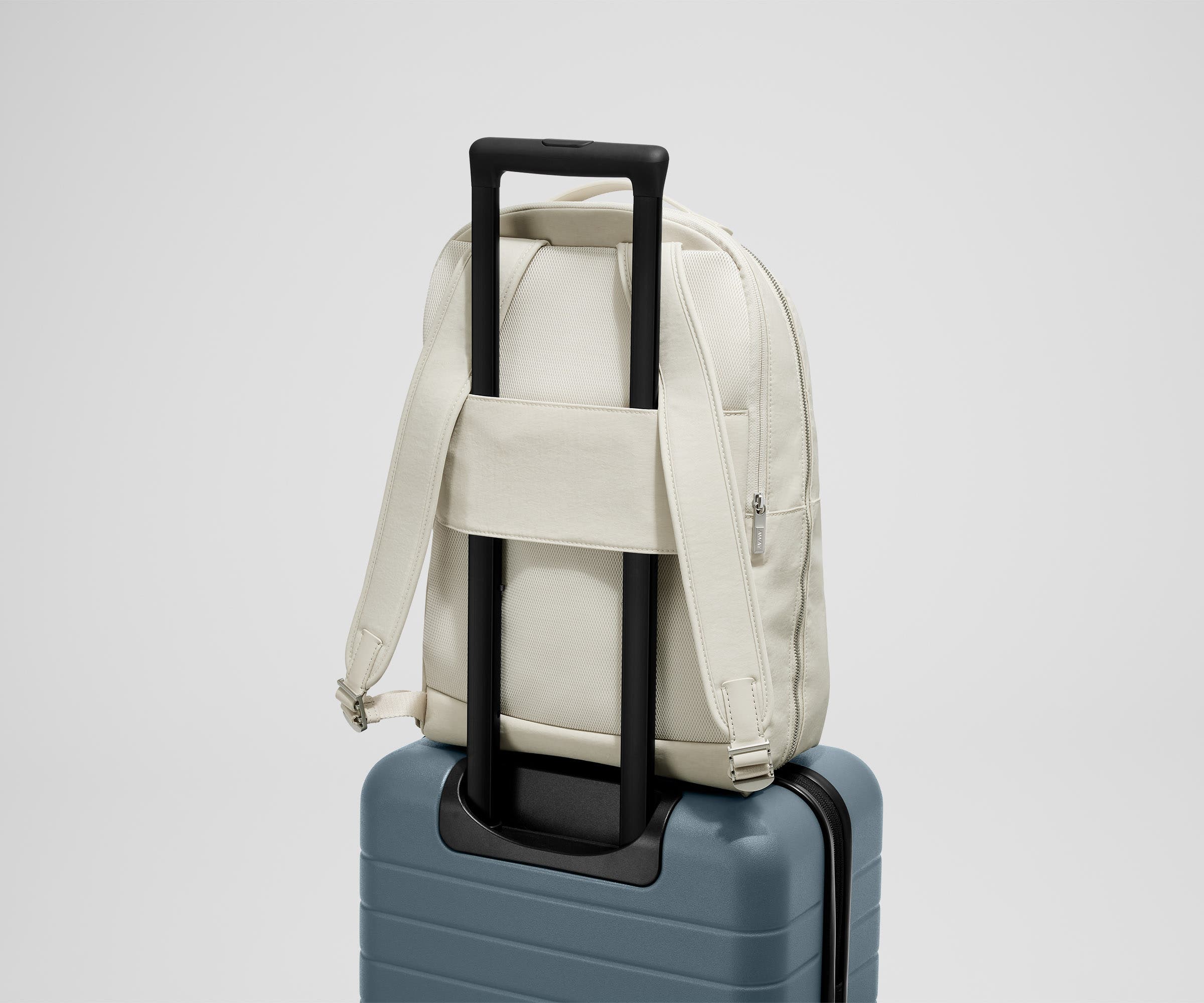 Back view of the Courtside Everywhere Zip Backpack on top of an Away suitcase