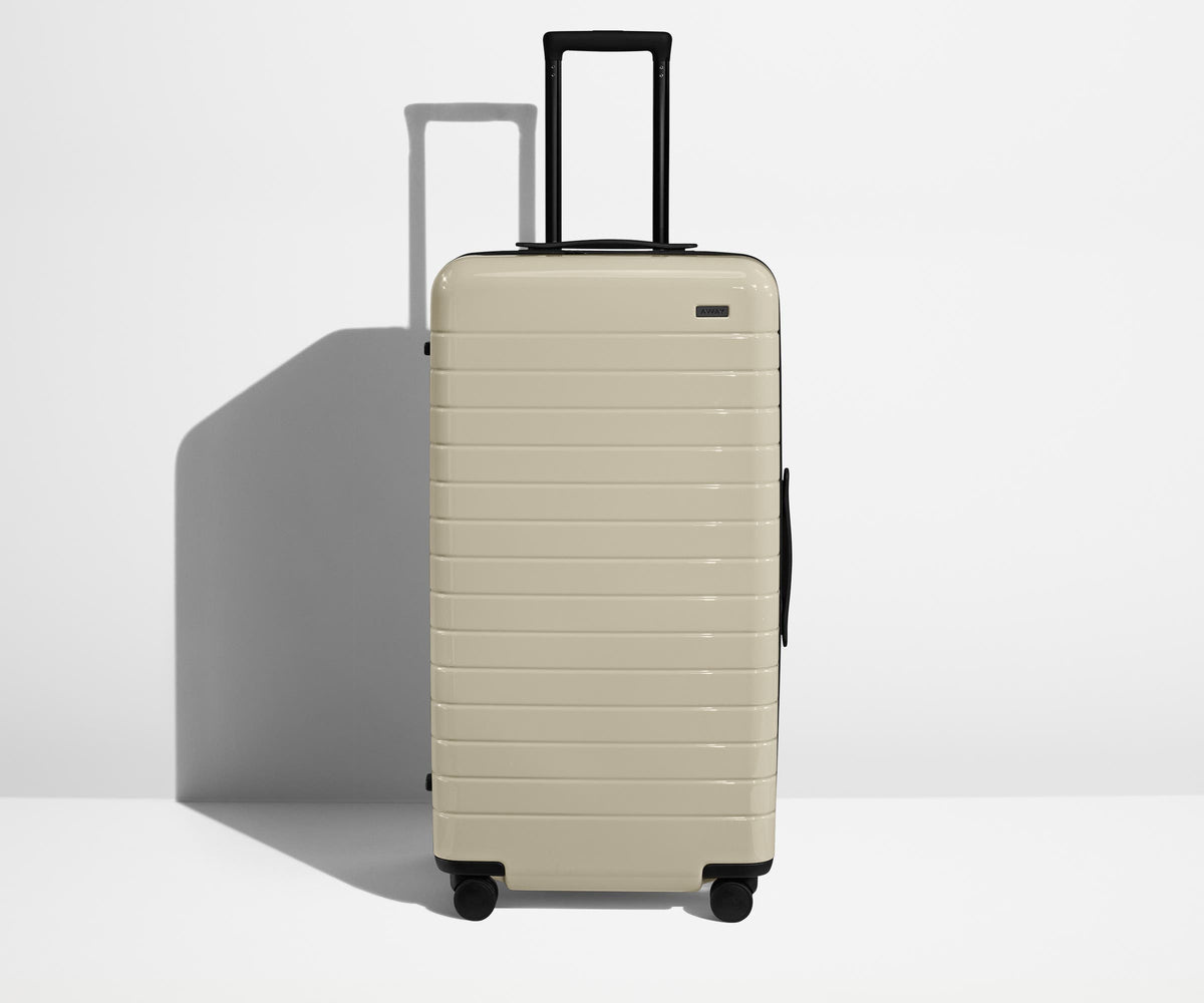 Front product view of The Trunk suitcase in Salt White (Gloss) with raised handle