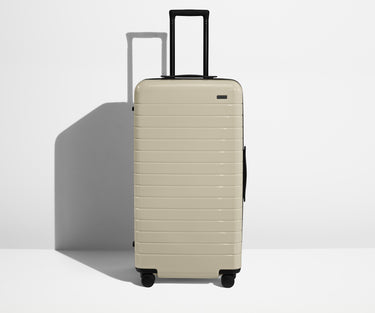 Front product view of The Trunk suitcase in Salt White (Gloss) with raised handle