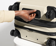 The Bigger Carry-On Flex suitcase in Salt White (Gloss) shown from below highlighting the underside grab handle