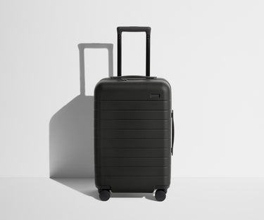 Front product view of The Carry-On suitcase in Jet Black with raised handle