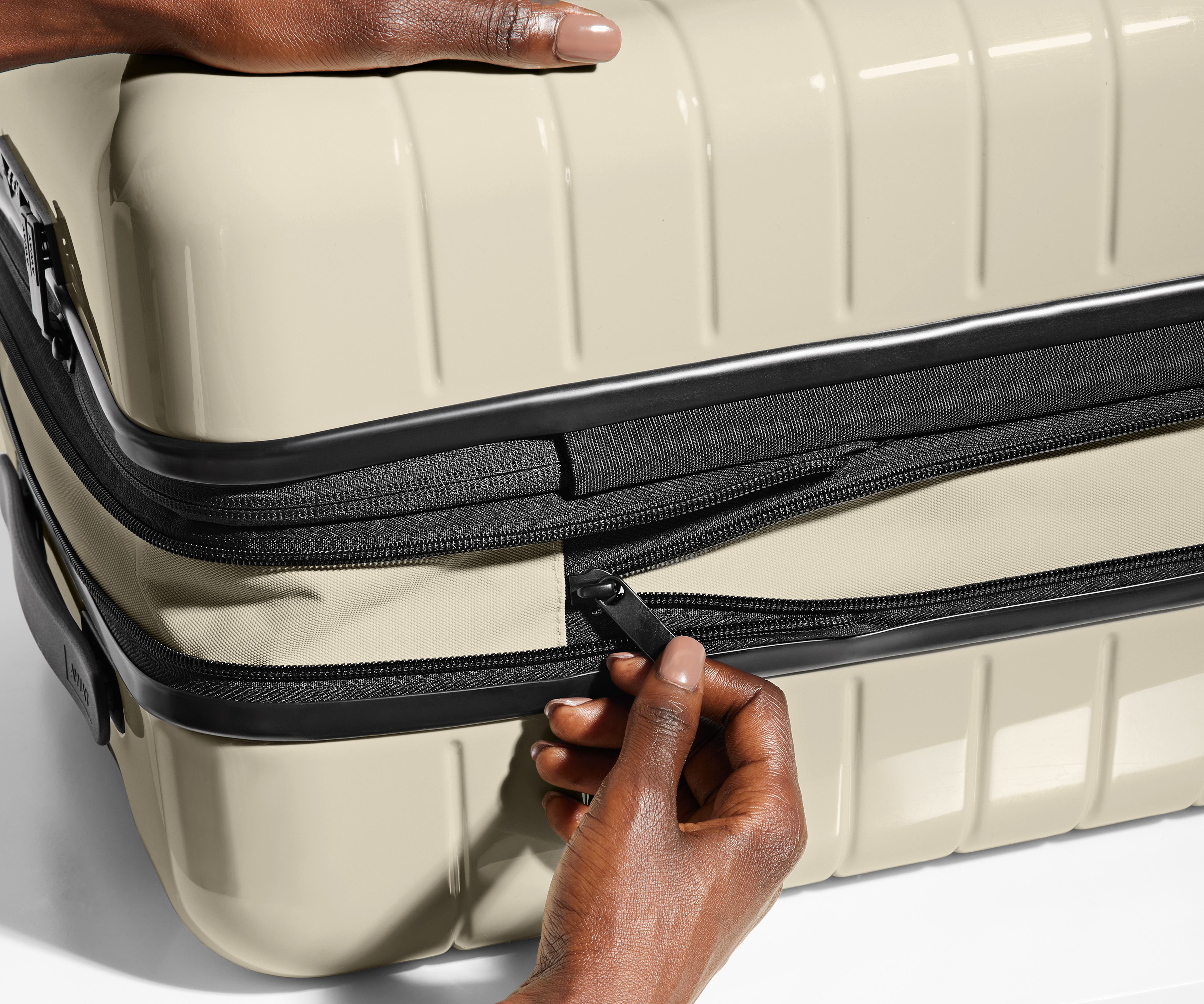The Bigger Carry-On Flex suitcase in Salt White (Gloss) has an additional wraparound zipper to expand the suitcase 2.25" (6 cm) and increase packing space