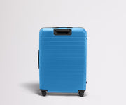 6'1" person walking with The Large Flex suitcase
