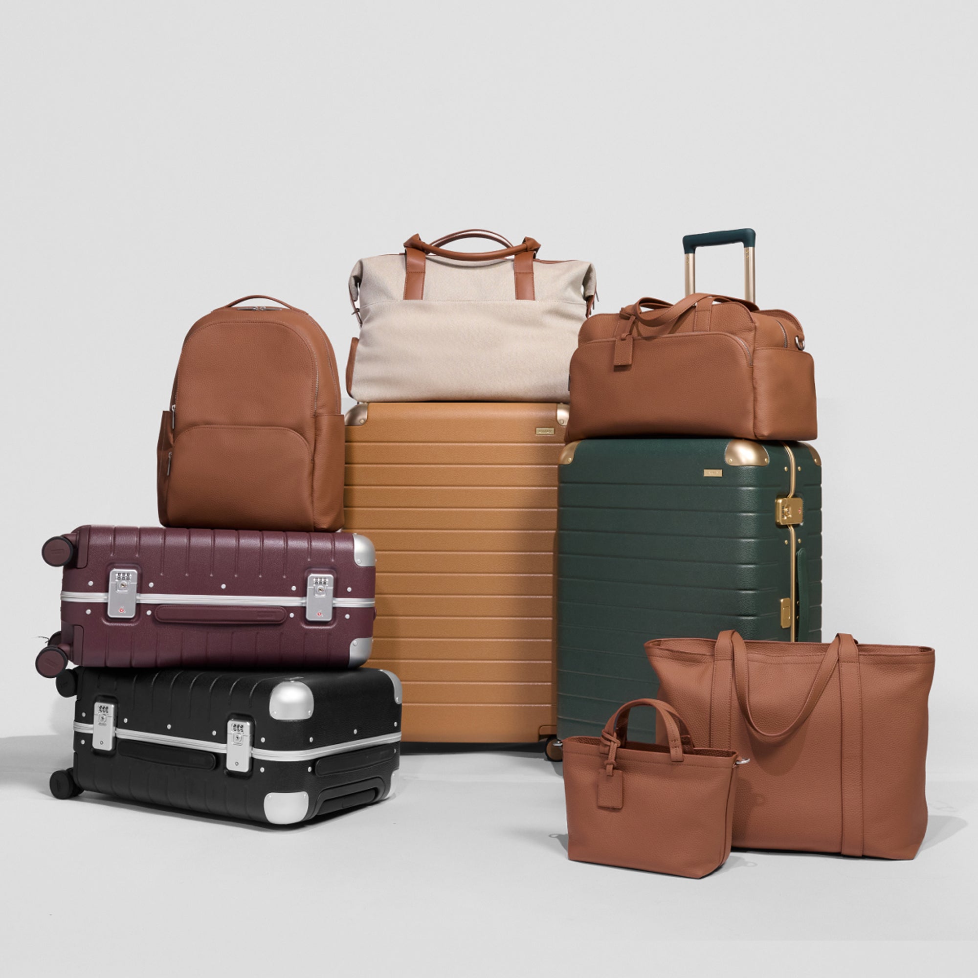 A man an woman in winter rolling 3 sets of Away luggage un blue, navy, and Aluminum silver