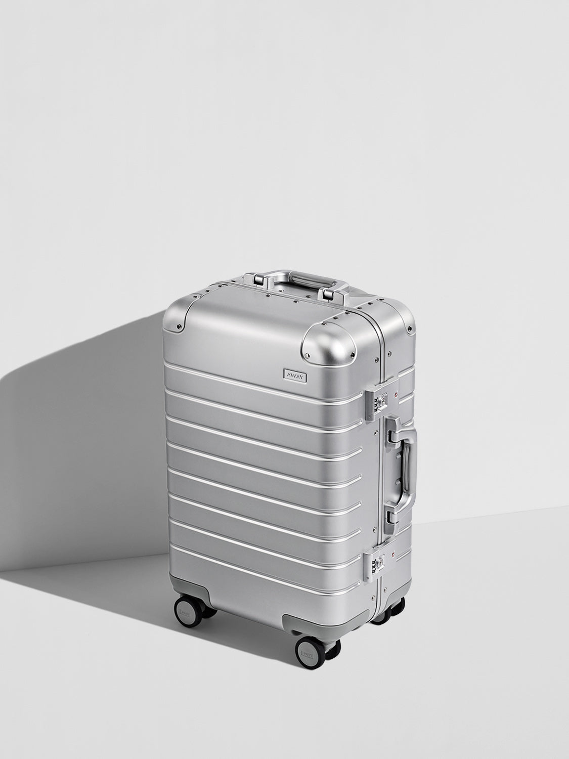 Silver premium aluminum carry-on suitcase with reinforced corners and spinner wheels