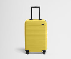 Front product view of The Bigger Carry-On suitcase in Sunshine Yellow with raised handle
