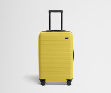 Front product view of The Bigger Carry-On suitcase in Sunshine Yellow with raised handle