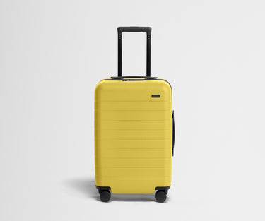 Front product view of The Carry-On suitcase in Sunshine Yellow with raised handle