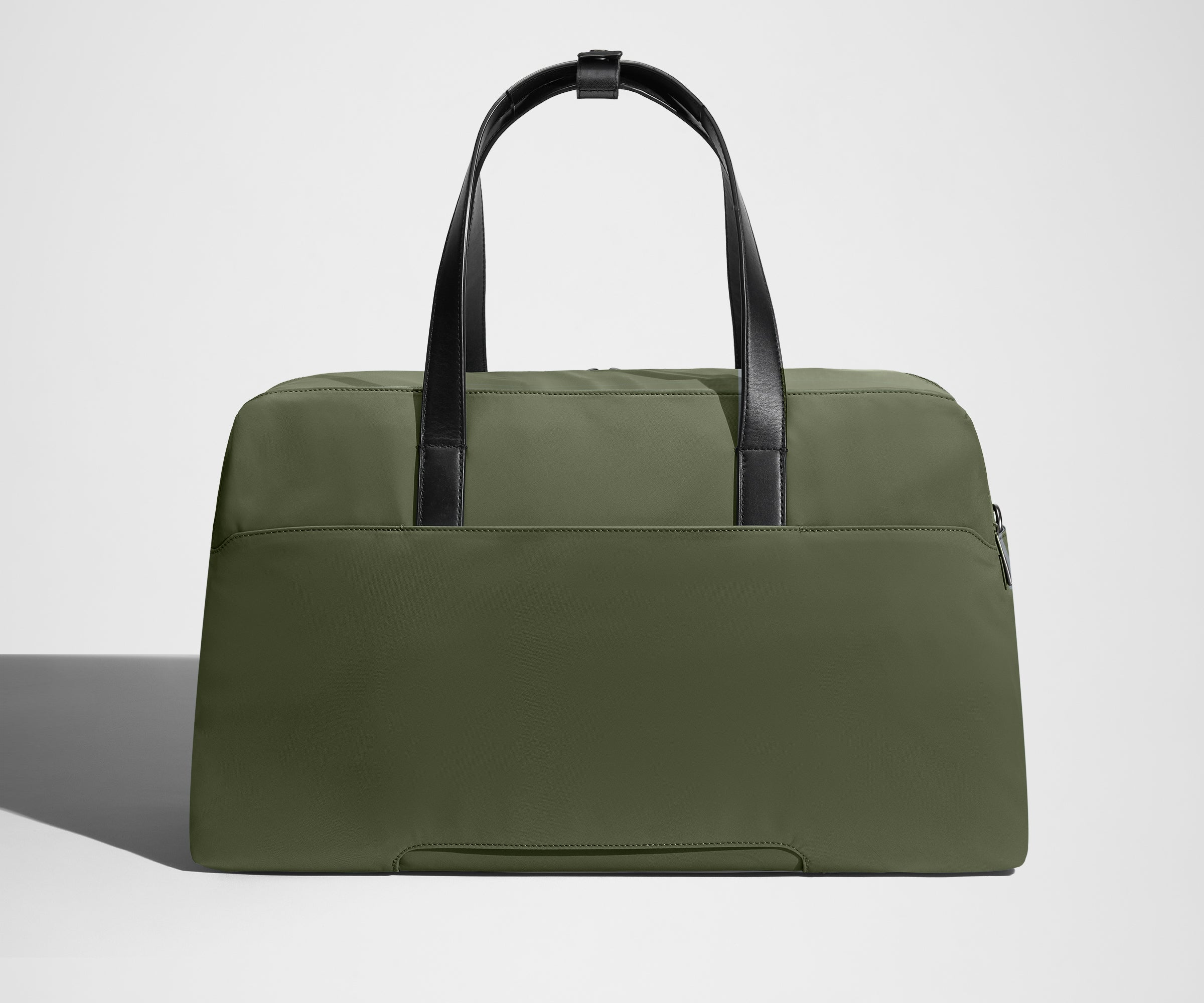 Green weekender bag with black handles on a light gray background