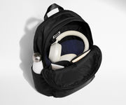 Front compartment packed with a notebooks, headphones, and clothing