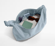 Featherlight crossbody packed with a sweater, notebook, sunglasses, and portable charger