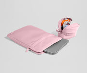 Pink laptop sleeve with a partially open view on a light gray background