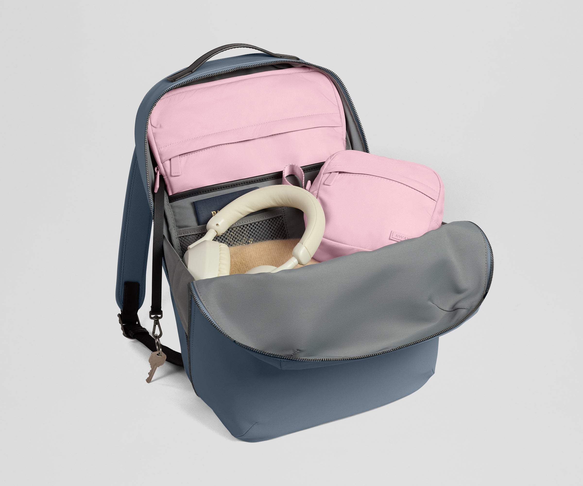 Open backpack with a pink laptop sleeve and tech case