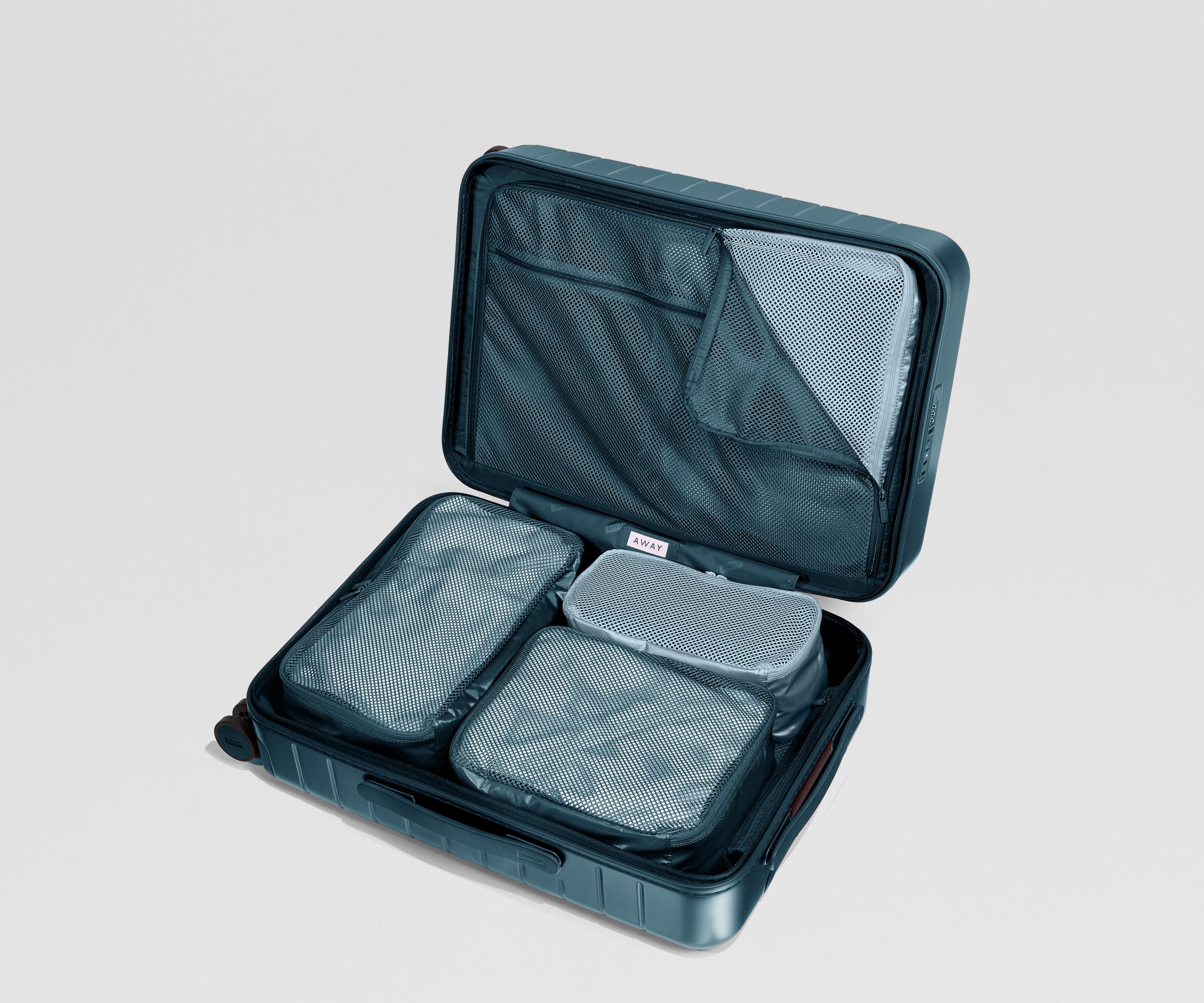 Open teal suitcase with mesh packing cubes on a light gray background
