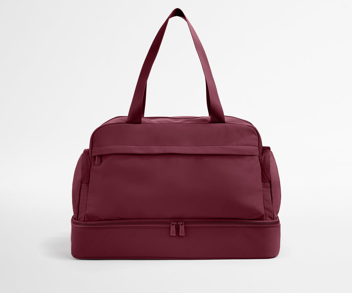 Maroon duffel bag on a light gray background