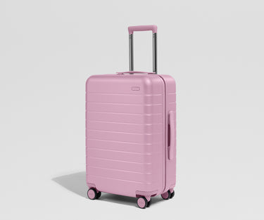 Pink suitcase on a light gray background