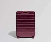 Maroon suitcase on a light gray background