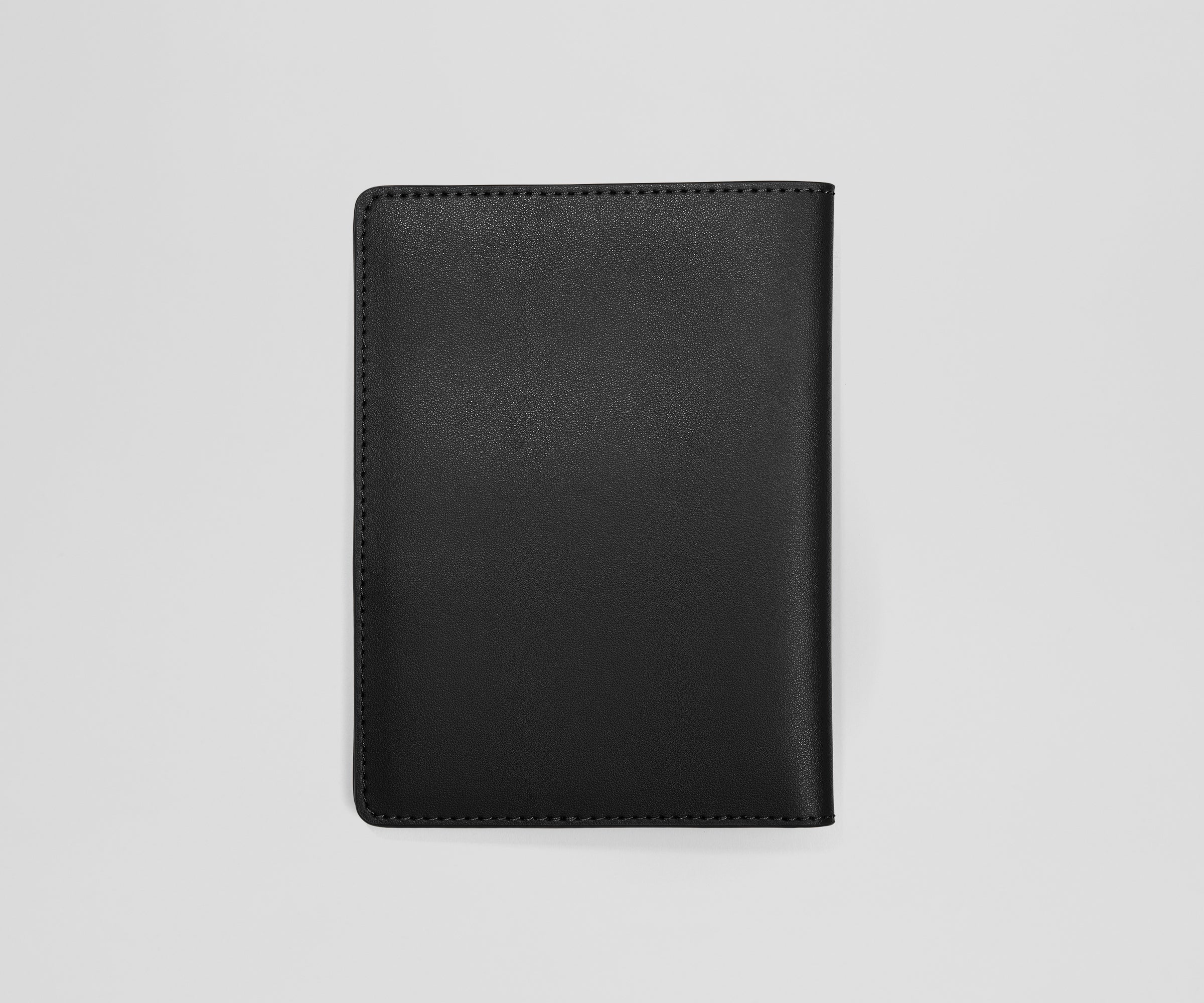 Black leather passport holder on a light gray background