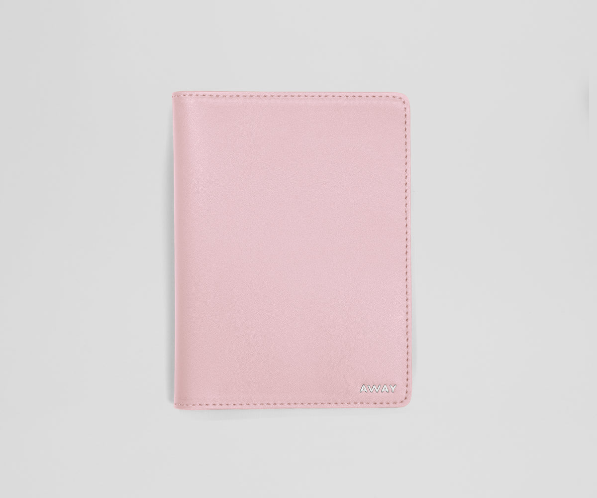 Pink leather passport sleeve on a light gray background