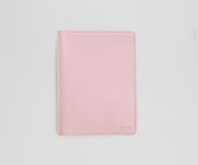 Pink leather passport sleeve on a light gray background