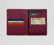 Maroon leather wallet with card slots and a passport holder on a light gray background