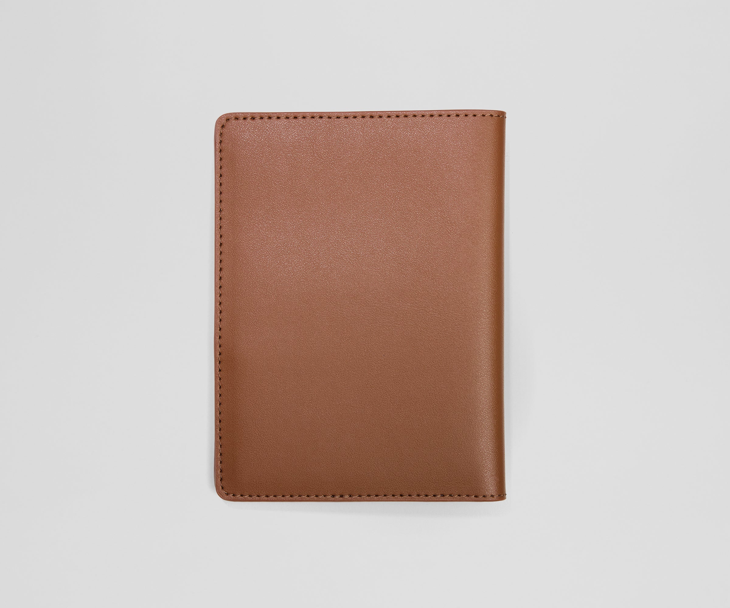 Brown leather passport holder on a light gray background