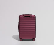 Maroon suitcase back view on a light gray background