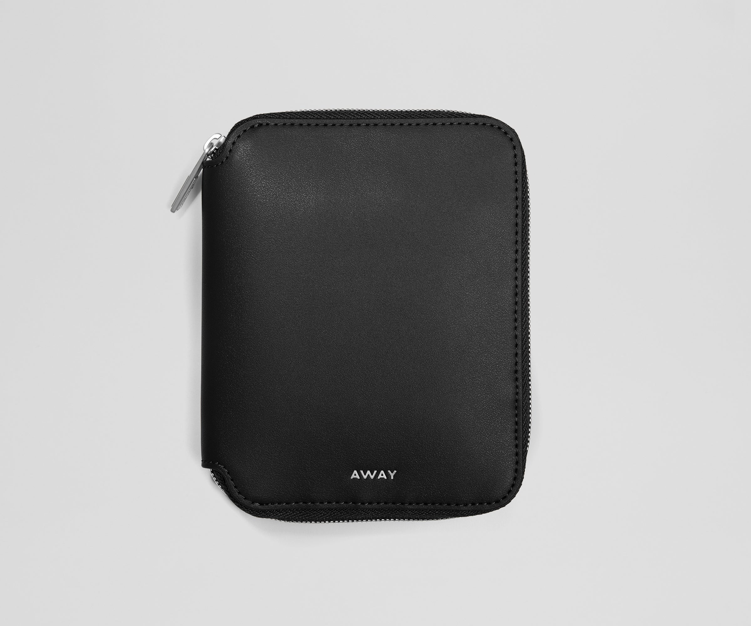 Black zippered jewelry organizer with 'AWAY' branding on a light gray background