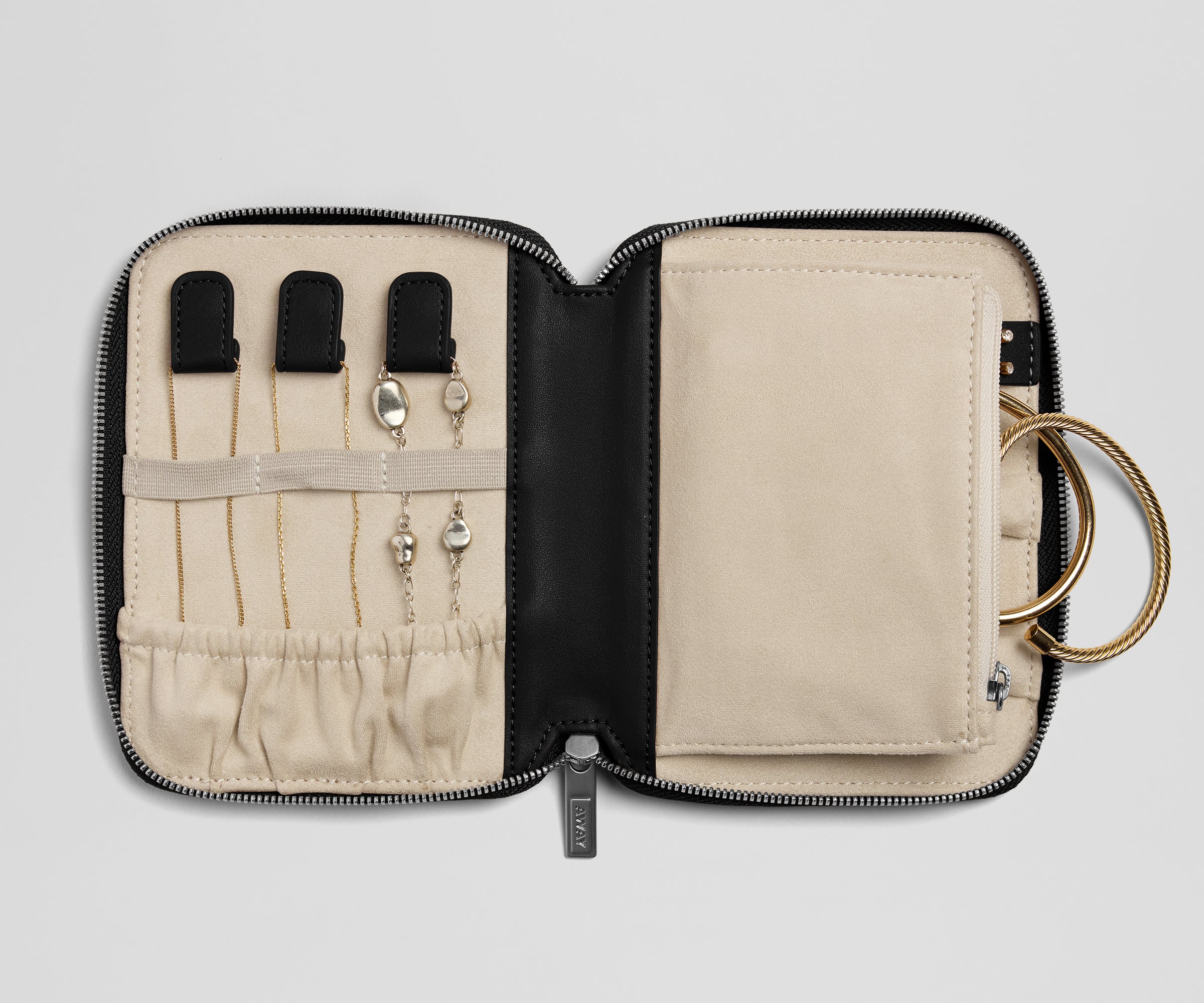 Jewelry case with earrings and a key on a light gray background