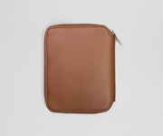 Brown leather zippered jewelry case on a light gray background