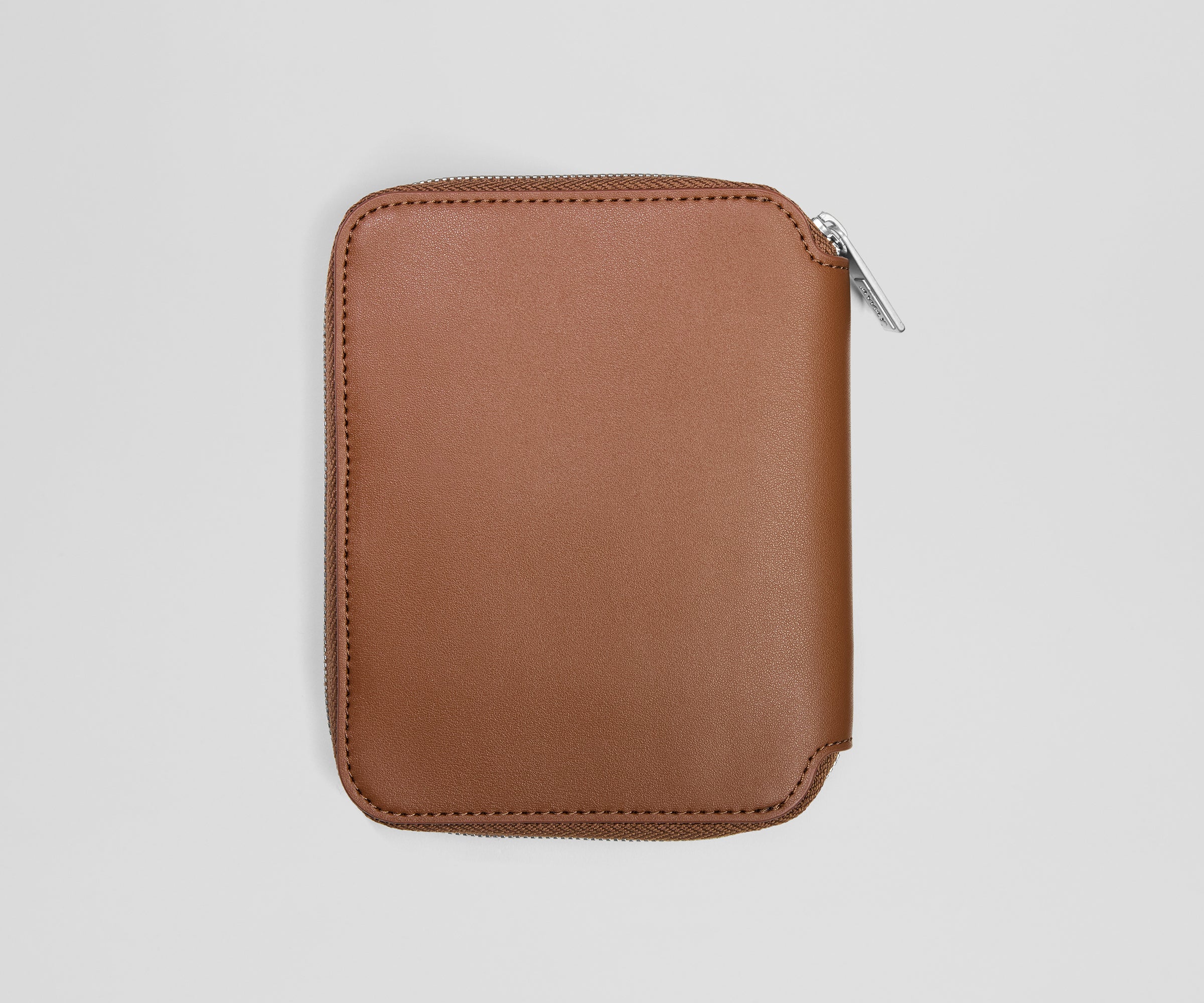 Brown leather zippered jewelry case on a light gray background