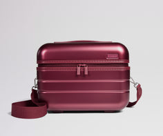 Red travel case with a strap on a light gray background