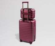 Red travel vanity case stacked on a matching suitcase
