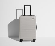 Front product view of The Bigger Carry-On suitcase in Cloud Gray with raised handle