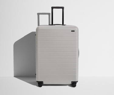 Front product view of The Large suitcase in Cloud Gray with raised handle