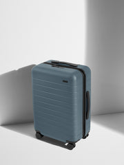 Angled view of the Bigger Carry-On suitcase in Coast Blue