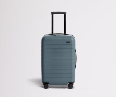 Front product view of The Carry-On suitcase in Coast Blue with raised handle