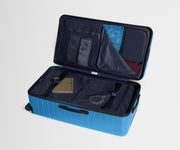 The Trunk suitcase in Splash Blue shown open on its side and packed with Away's packing organizers to show capacity and the interior compression system, designed to help you pack more in