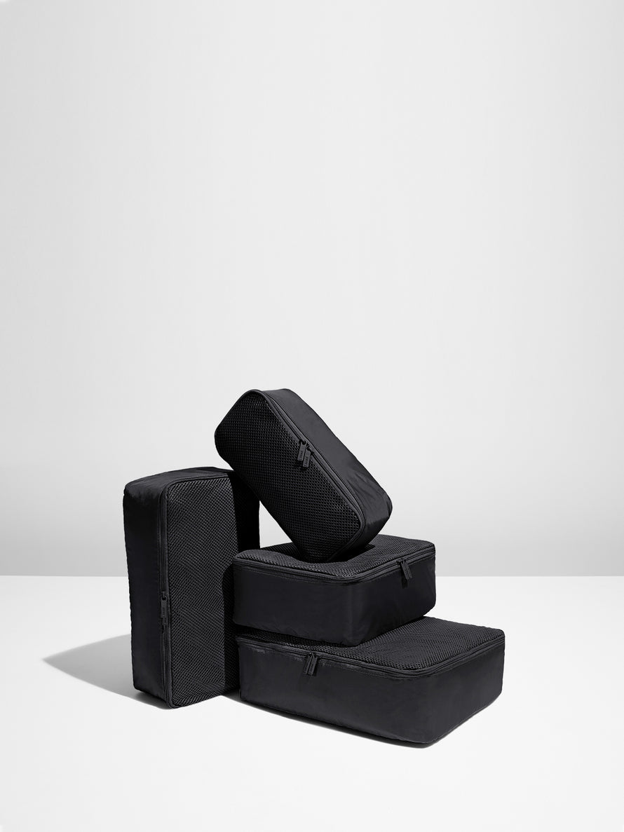 Four Black packing cubes stacked on each other