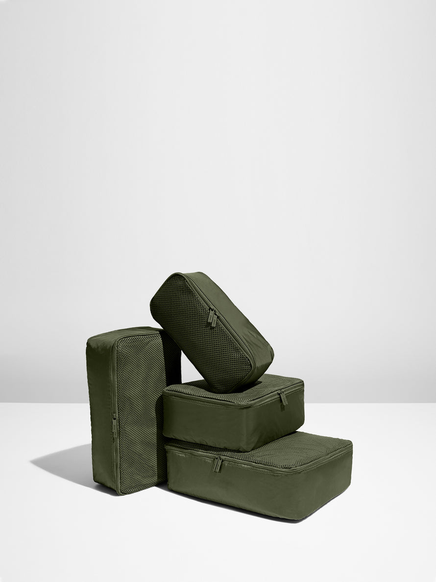 Four Olive Green packing cubes stacked on each other
