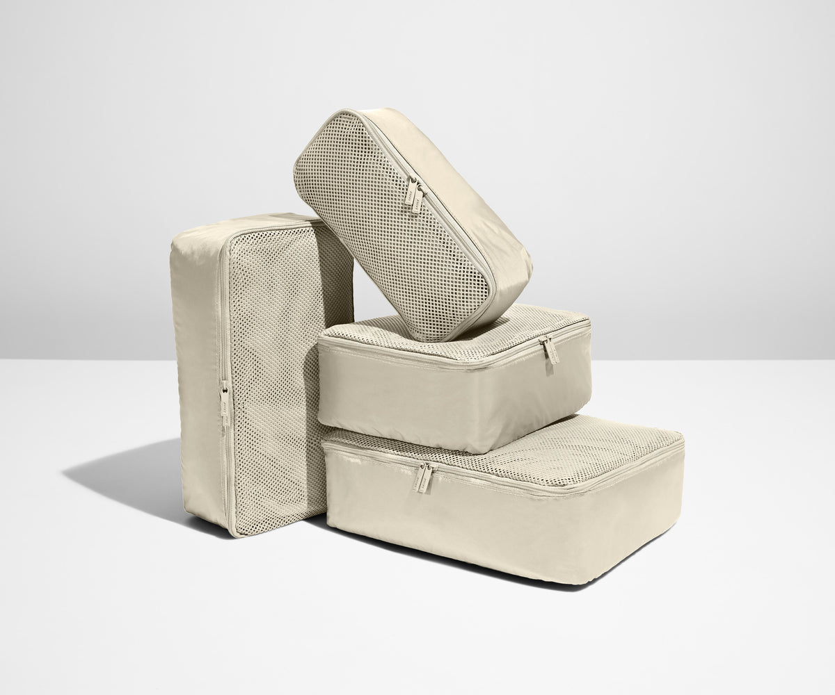 A set of four packed Insider Packing Cubes stacked on top of each other