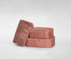 A set of four packed Insider Packing Cubes stacked on top of each other