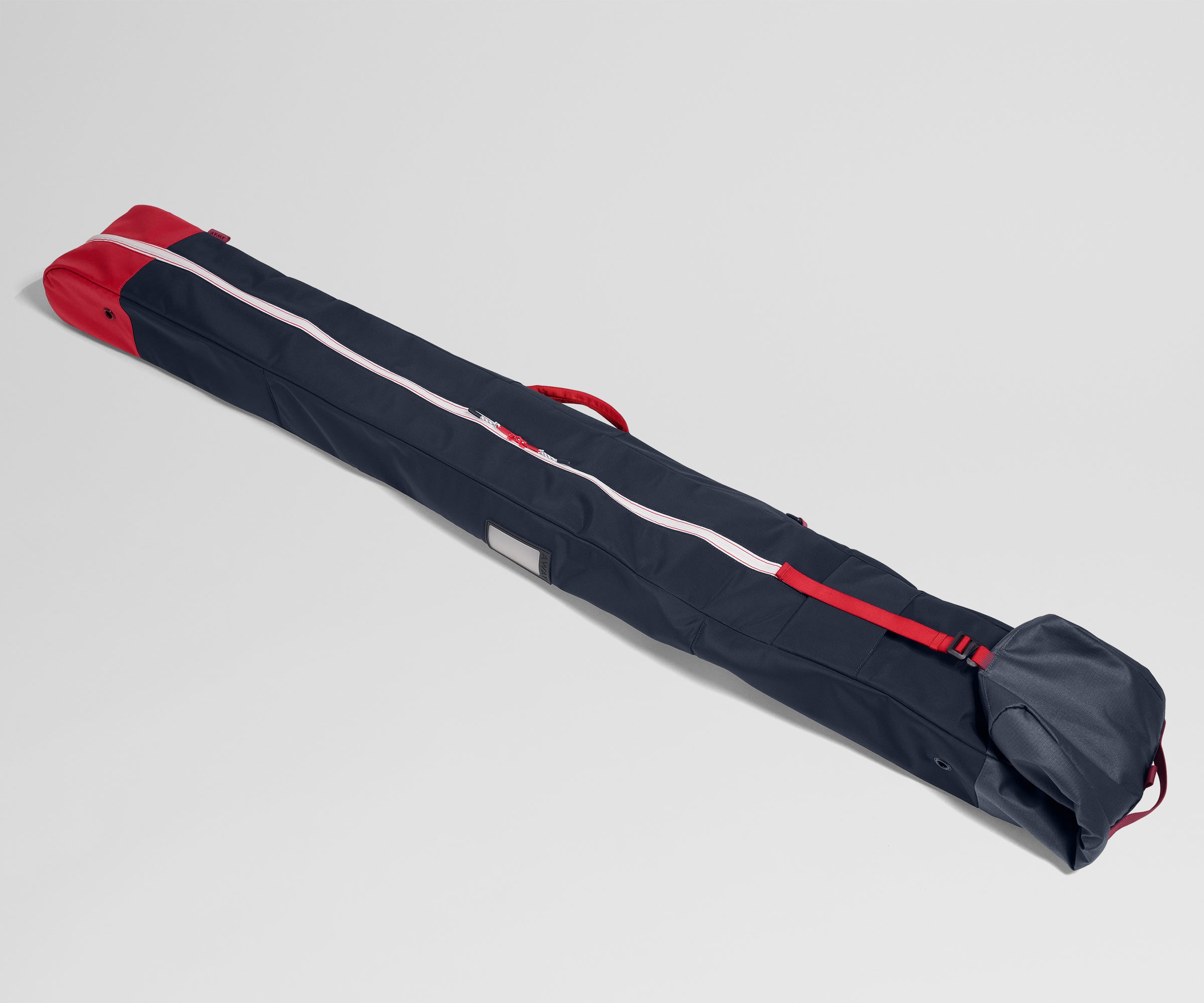 Navy blue and red ski bag on a light gray background