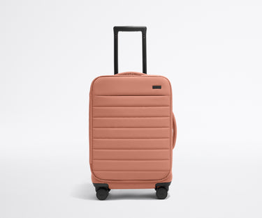 Front product view of The Softside Carry-On suitcase in Clay Pink with raised handle
